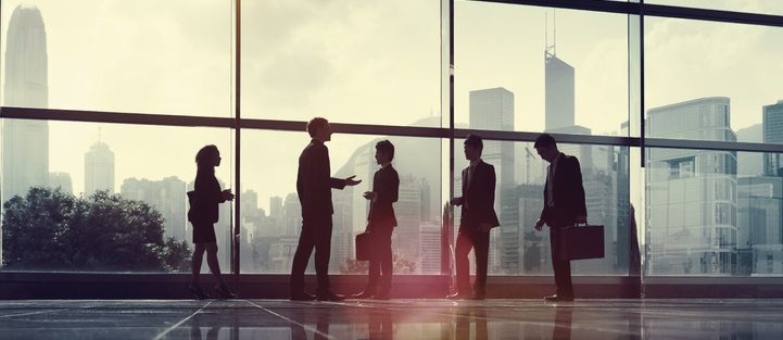 5 people standing in front of a window at an office