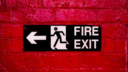 Fire exit sign on a red brick wall