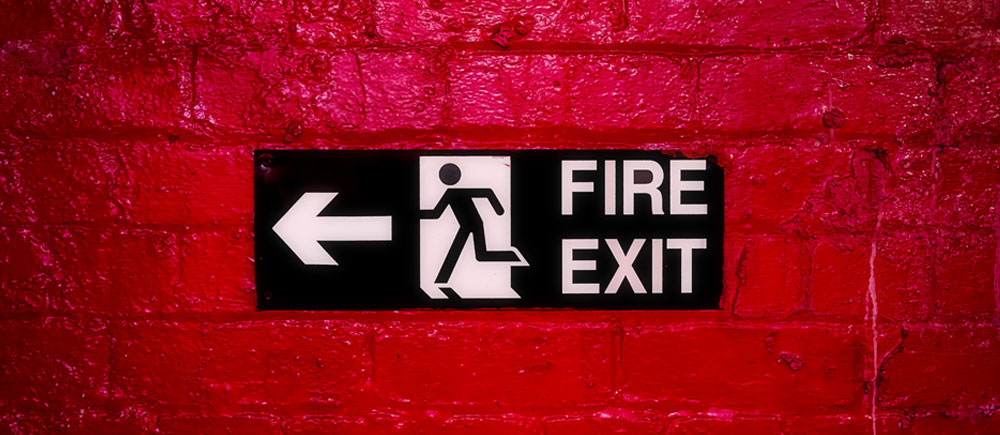 Fire exit sign on a red brick wall