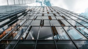 Looking up towards a commercial building with reflective windows