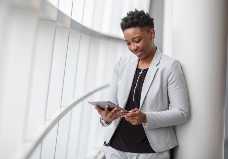 Female business professional wearing a suit and holding a tablet