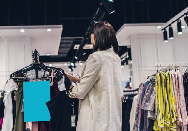 Woman looking through a clothing rack in a store