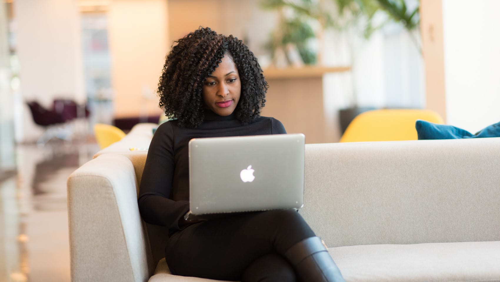 Woman sitting on couch at computer