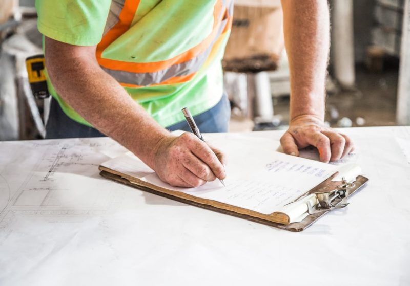 Construction worker writing notes on a piece of paper