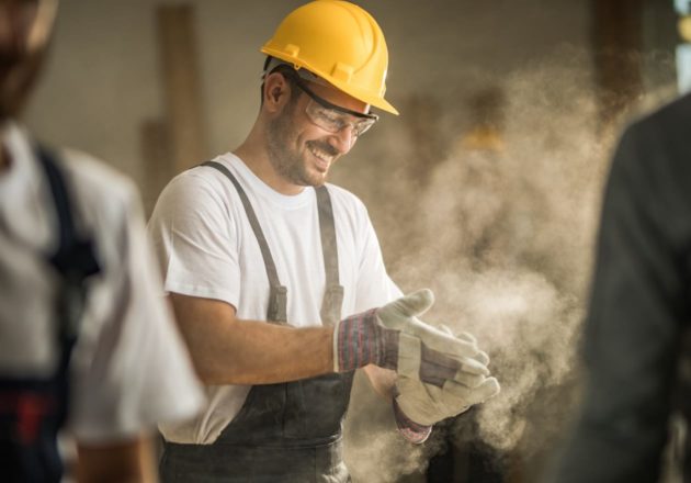 Male engineer wearing a hard hat and dusting gloves