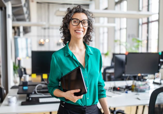 Older female employee holding a computer