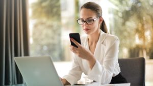 Woman using her phone and laptop