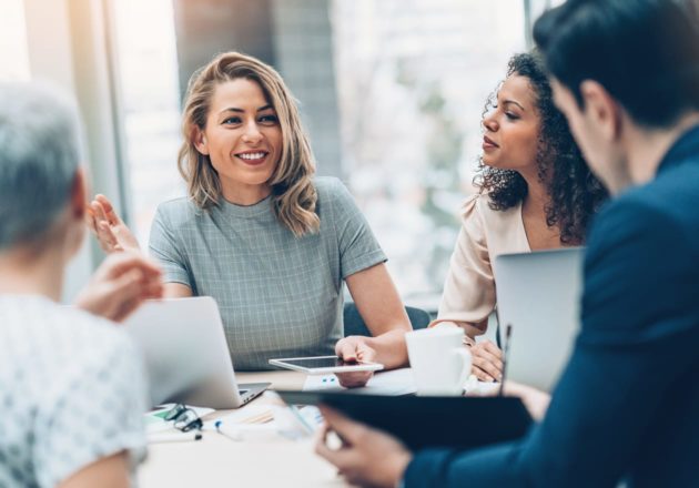 Female tenants speaking to a group of people at a desk