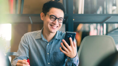 A man looks at his phone and smiles