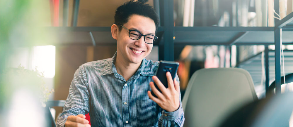 A man looks at his phone and smiles