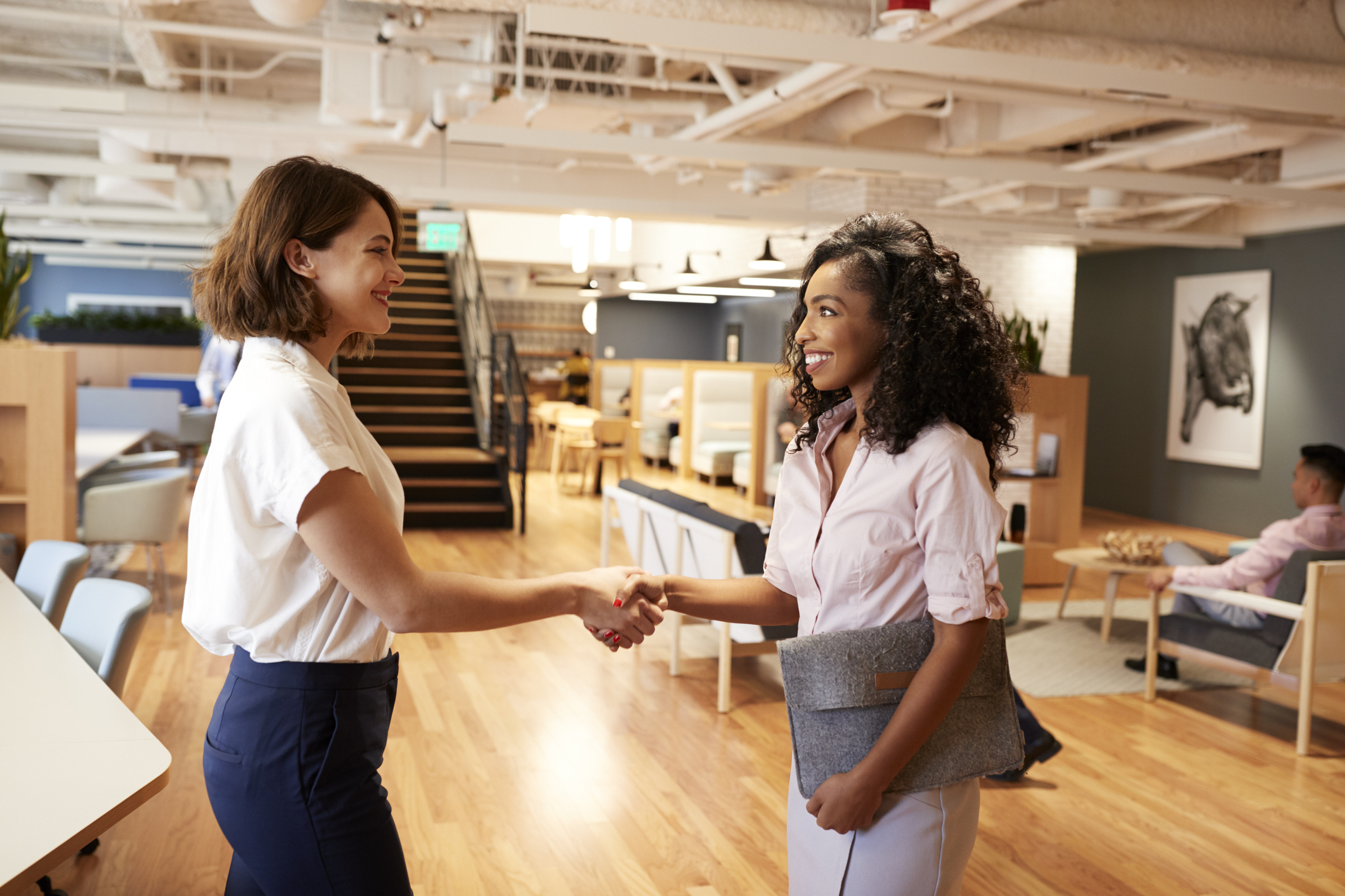 Woman shakes hands with new vendor procured via vendor RFP