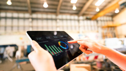 A worker is using tablet to review storage report - Business management and technology concept photo.