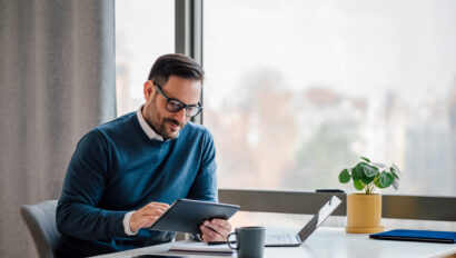 Young businessman using digital tablet while working in business office.