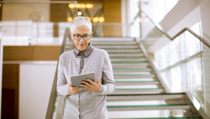 Modern senior businesswoman using tablet computer at office