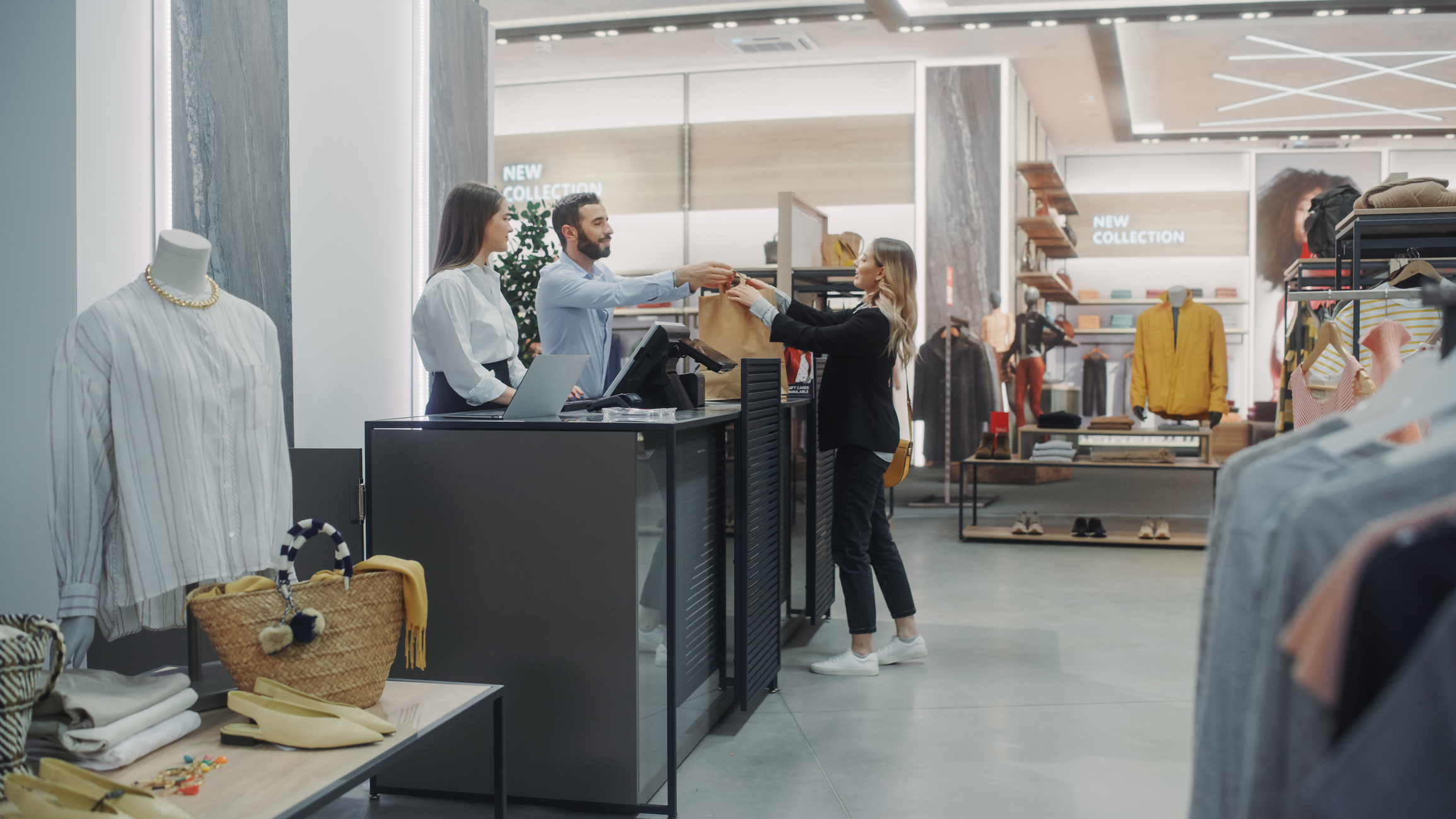 Clothing Store Checkout Cashier Counter: Beautiful Young Woman Buys Blouse from Friendly Retail Sales assistant, Receiving Bag with Purchases. Trendy Fashion Shop with of Designer Brands